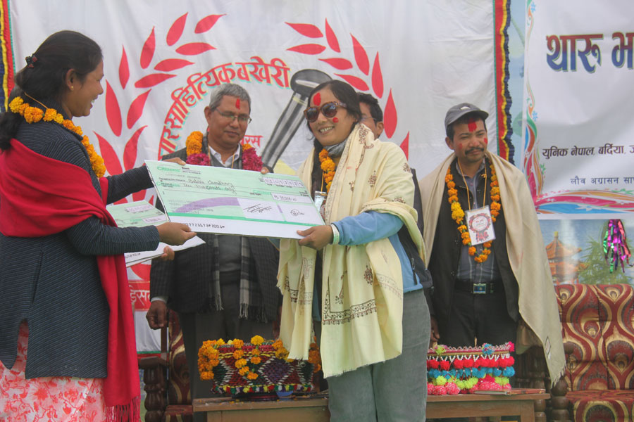 Tharu Female Writer - Balika Chaudhary receiving award from Tharu Home Resort Owner